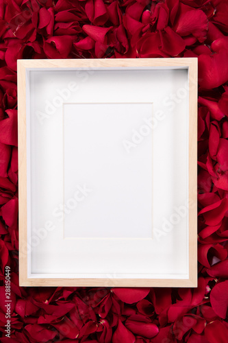 Wooden frame lying on rose petals