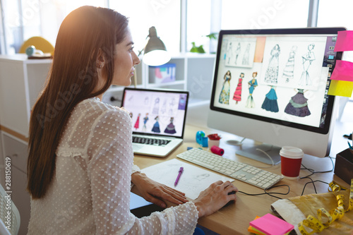 Female fashion designer working on computer at desk  photo
