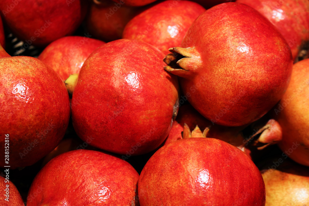 Many bright red ripe pomegranate fruits at market place Many bright red ripe pomegranate fruits at market place