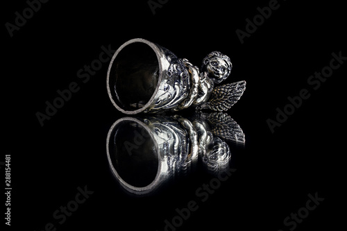 bell with an angel on a mirror on a black background isolate