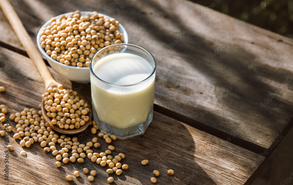 Soy milk cool and soybeans on wooden table background with lighting in the morning Soy milk cool and soybeans on wooden table background with lighting in the morning