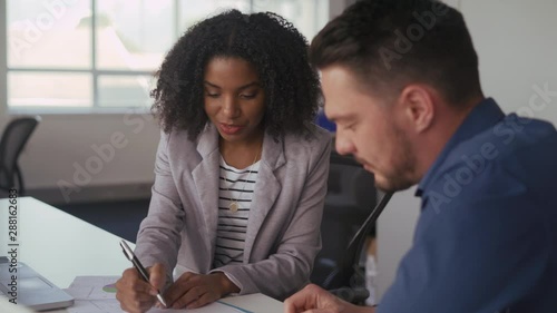 Successful young diverse business colleague talk and discuss about business work on the table in the office