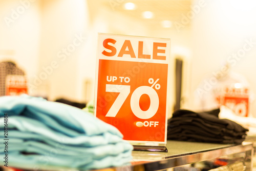 sale sign stands on a rack with things in the store