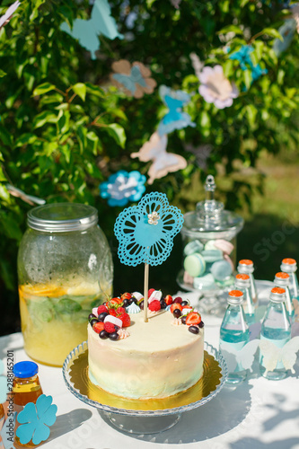 cake decorated with colored glaze  strawberries  grapes and marshmallows