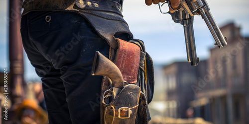 Foto Man holding two six-shooters ready for a gunfight, Western movie set
