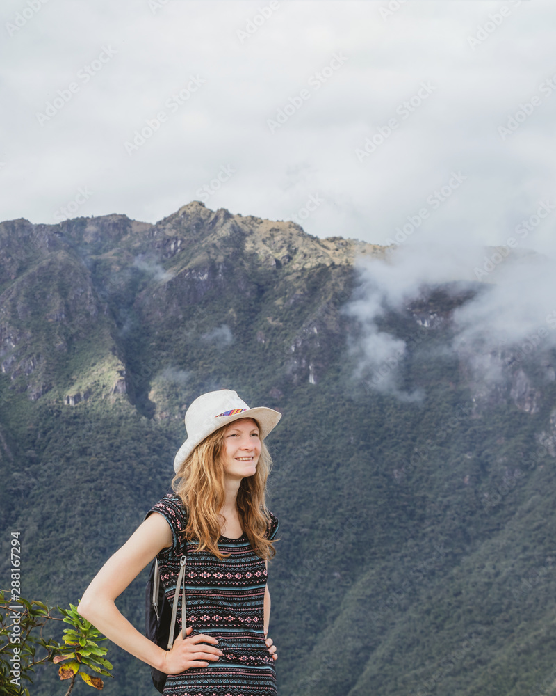 Young caucasian happy woman in Machu Picchu mountain and looking away in Peru. Back view with copy space