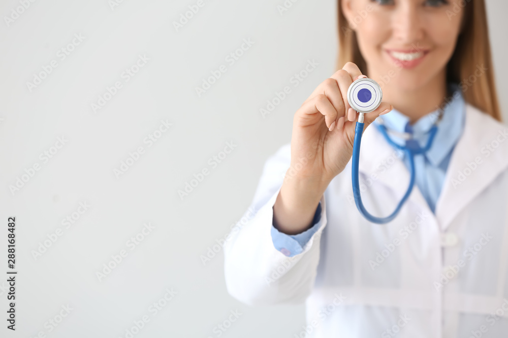 Female doctor with stethoscope on light background Female doctor with stethoscope on light background