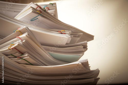 Stack of vintage document paper with colorful paperclip.