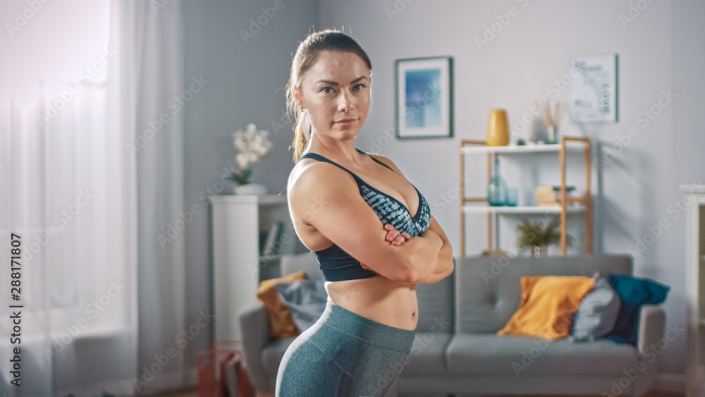Strong and Fit Beautiful Busty Girl in an Athletic Top is Posing With a  Soft Smile Showing Her Figure. Bright and Spacious Living Room with  Minimalistic Interior. Stock-Foto | Adobe Stock