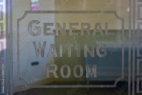 An etched glass Waiting Room sign