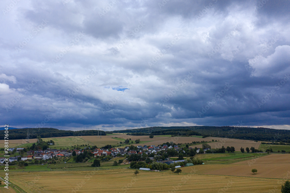 Blick auf ein kleines Dorf im Taunus/Deutschland bei Gewitterstimmung