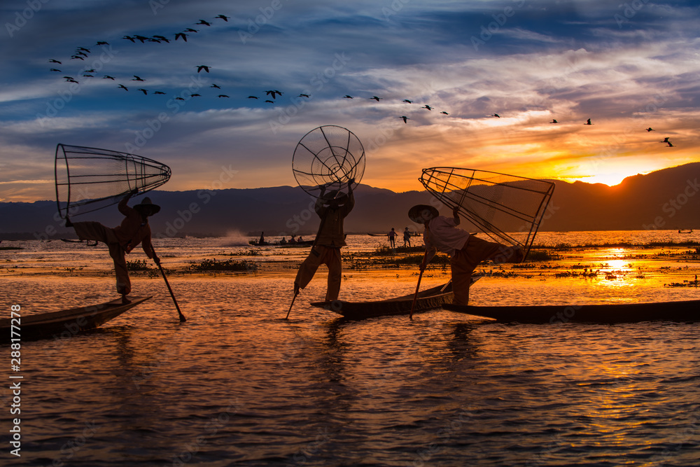 Burmese Fishermen posing with conical nets at sunset, Inle Lake in the Nyaungshwe Township part of Shan Hills in Myanmar Burma