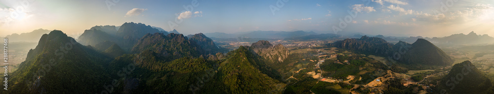 Fototapeta premium Beautiful City of Vang Vieng aerial Panorama Limestone Mountains at Sunset