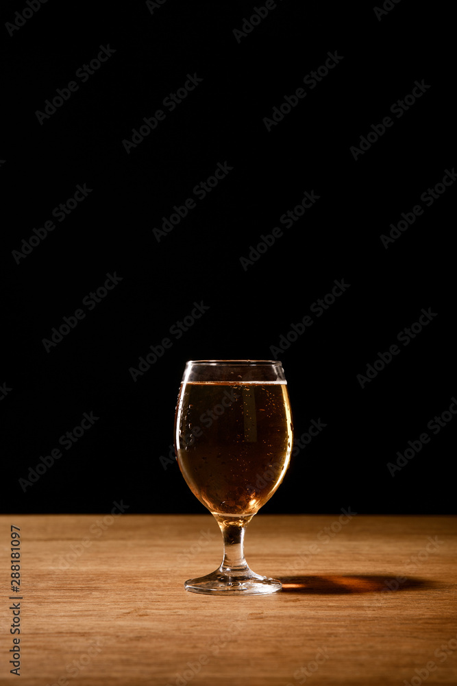 glass of fresh beer on wooden table isolated on black glass of fresh beer on wooden table isolated on black