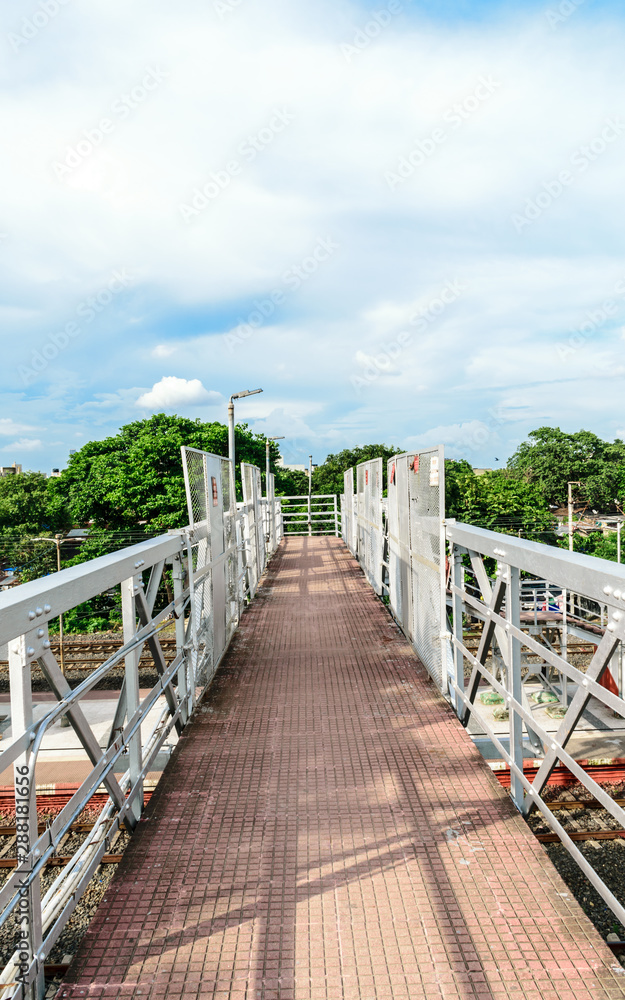 Obraz premium Railway foot over bridge or simply called an Over bridge on a railway station platform almost complete for passengers to pass over a railway station platform. South astern Railway, Kolkata, India