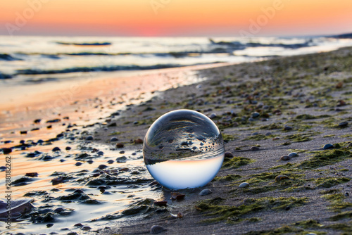 Szklana kula na brzegu morza. Piękny wschód słońca © VinyLove Foto