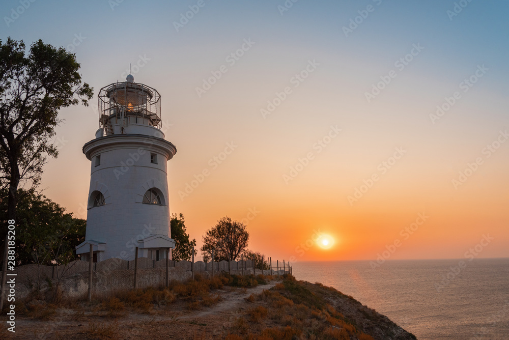 White sea lighthouse in Feodosia, Crimea on the Black Sea from sunrise