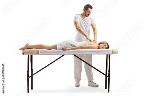 Professional masseur giving massaging a woman on a bed