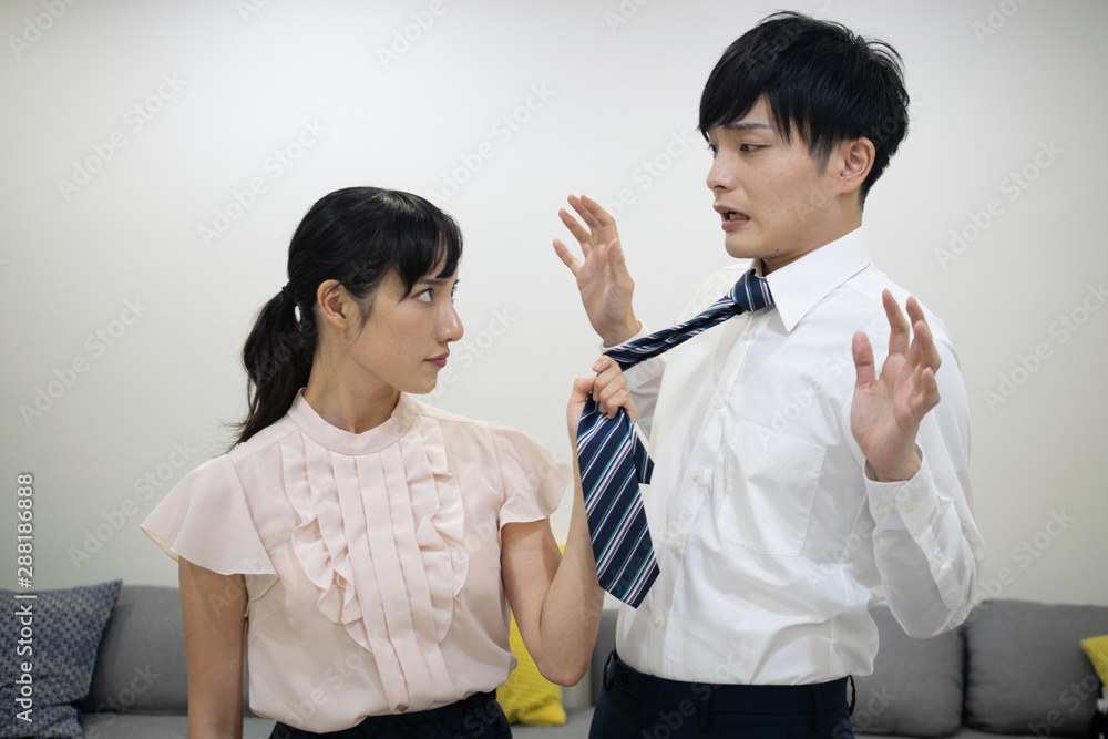 ネクタイをつかんで夫に詰め寄る妻 ネクタイをつかんで夫に詰め寄る妻