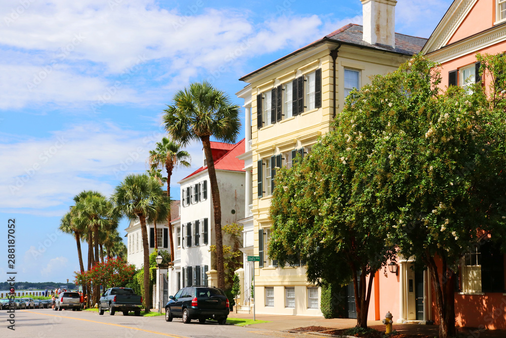 Street view with beautiful buildings,  palm trees and parked cars in the historic downtown area city of Charleston, South Carolina, USA. Southern style architecture background.