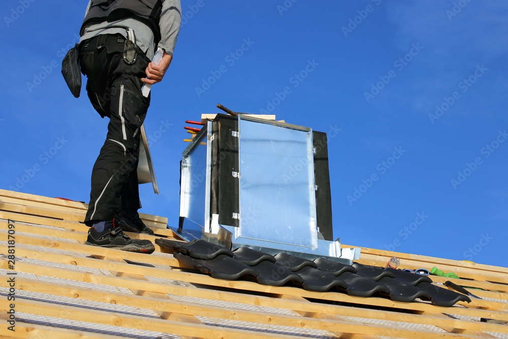Roofer working on exterior chimney cladding Roofer working on exterior chimney cladding
