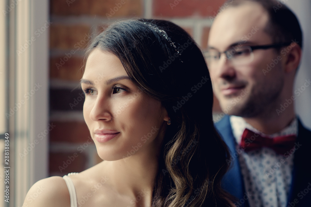 Naklejka premium European bride and groom standing near each other and looking in the same direction.