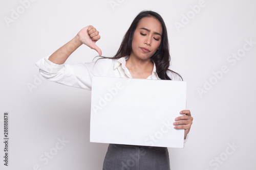 Young Asian woman show thumbs down with white blank sign.