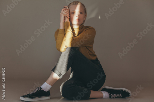 Young human in casual wear sitting in light room photo