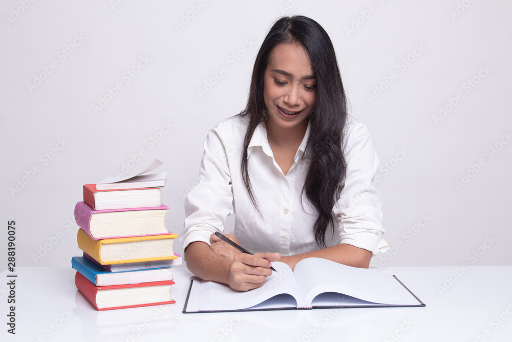 Young Asian woman read a book with books on table. Young Asian woman read a book with books on table.