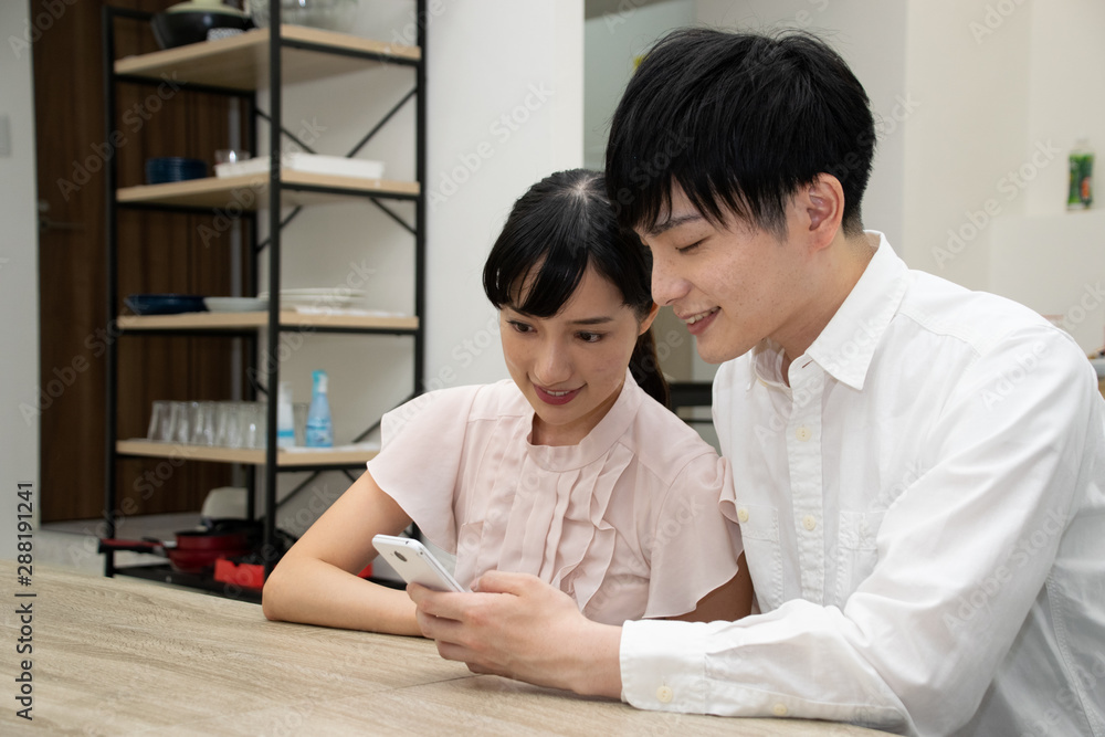 スマートフォンを見て笑顔の二人 スマートフォンを見て笑顔の二人