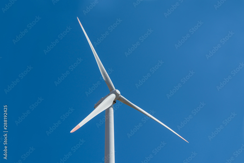Wind turbine close up against a blue sky background