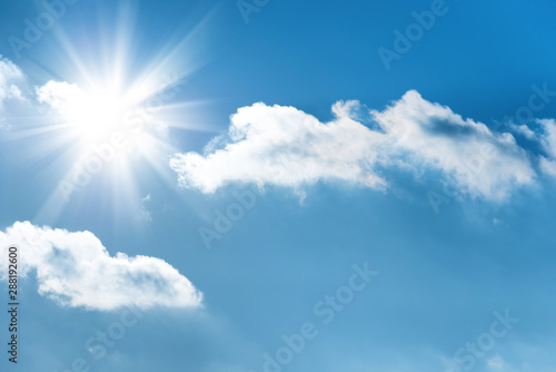 Sun with sun rays on the blue sky with clouds