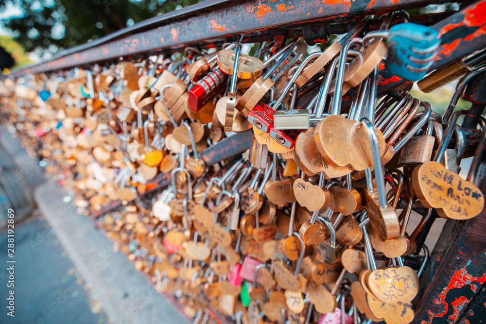 Fototapeta premium Lovers hang padlocks on bridges and fences in Paris, causing heated debate among the urban public