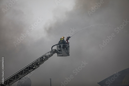 people firefighters on a fire escape extinguish a fire