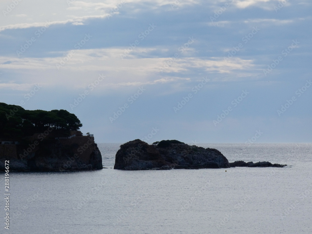 Paisaje de la Costa Brava catalana, España, con el mar azul, islas, aguas cristalinas, árboles y acantilados