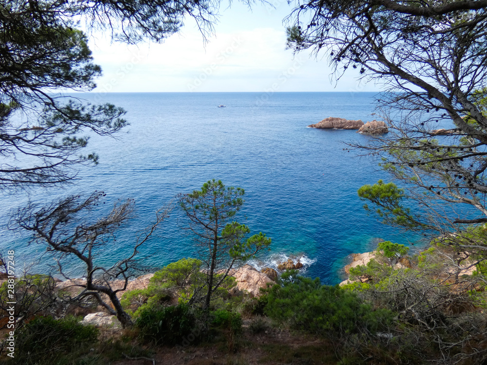 Paisaje de la Costa Brava catalana, España, con el mar azul, islas, aguas cristalinas, árboles y acantilados