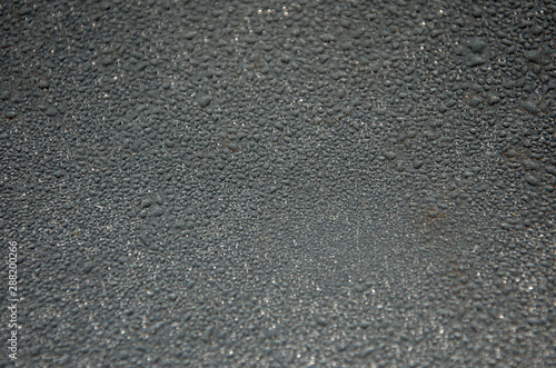 Background, water droplets on a gray glossy surface.