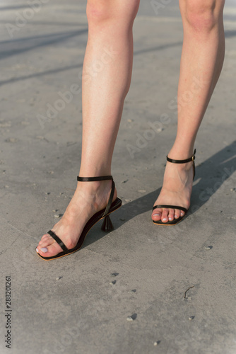 Classic, casual, nude black shoes with a thin strap on the girl s legs
