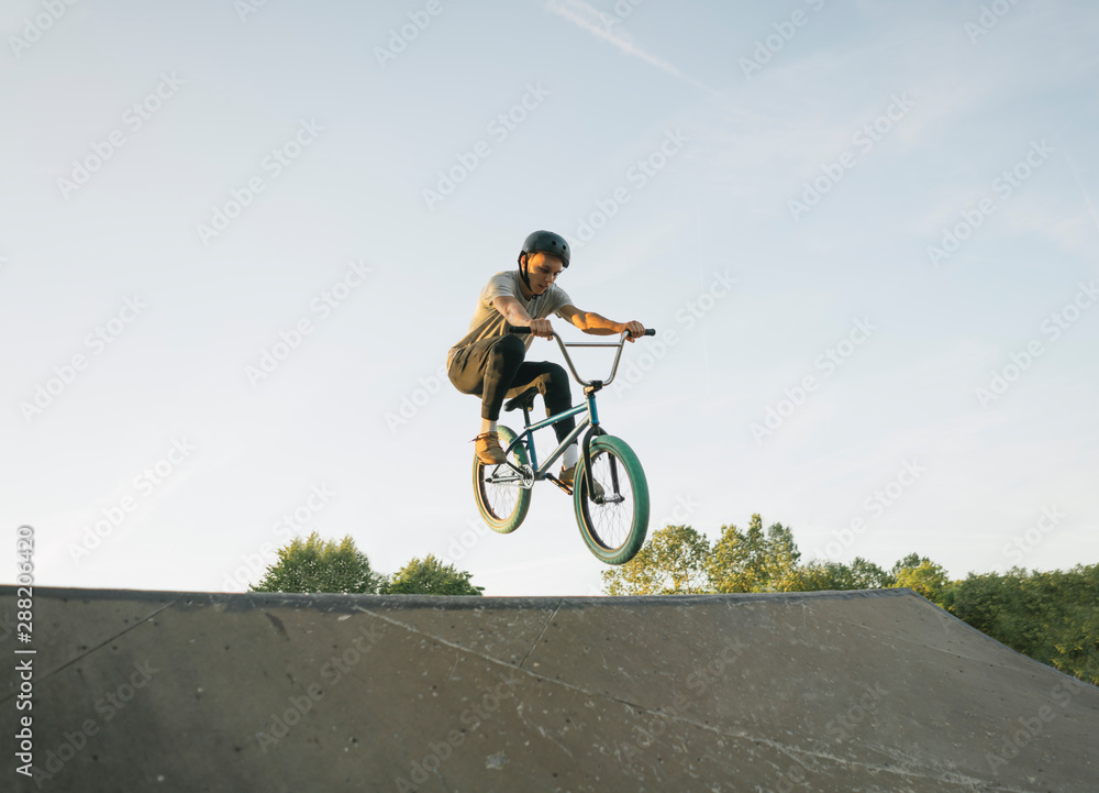 Young man riding BMX bike at skate park