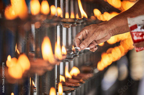 Hand lighting candle at Temple of the Sacred Tooth Relic, Kandy, Sri Lanka photo