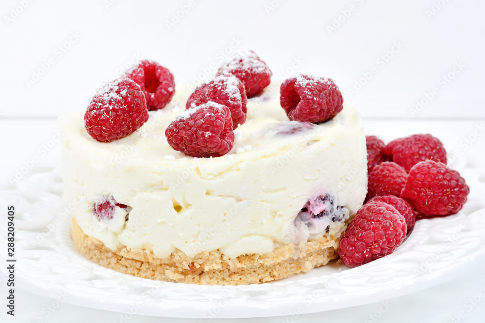 Mini cheesecake with white chocolate and raspberries on a white wooden background Mini cheesecake with white chocolate and raspberries on a white wooden background