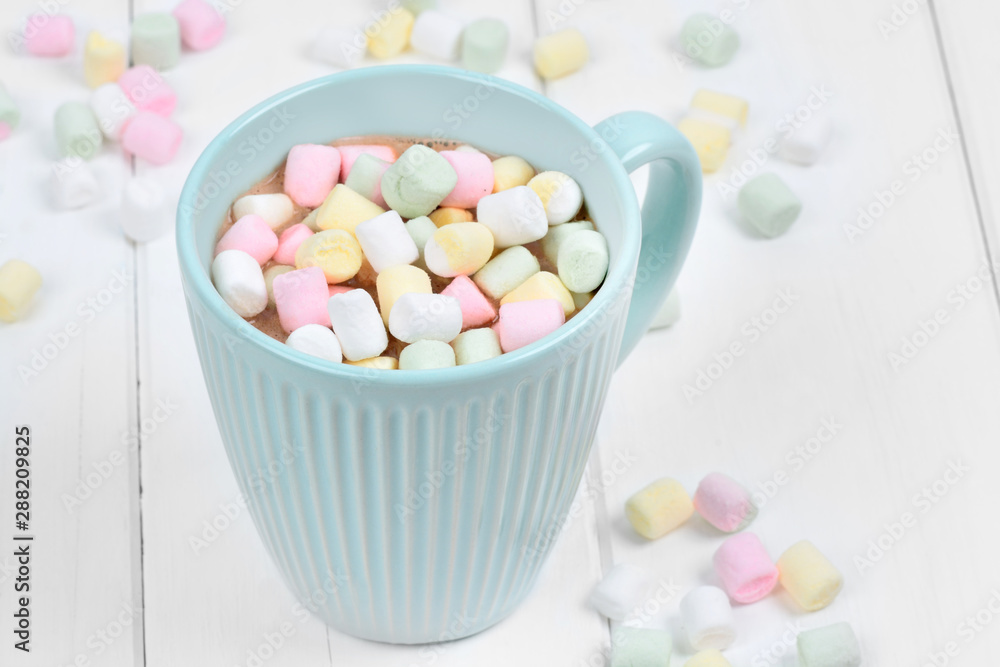 Hot chocolate with colorful marshmallows in a cup on a wood table Hot chocolate with colorful marshmallows in a cup on a wood table