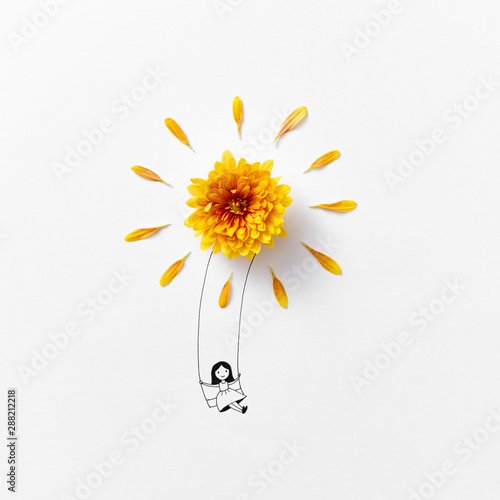 Pen drawing a smiling girl on a swing decorated with natural fre