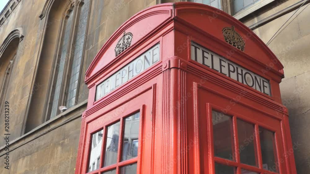 A red phone booth near an ancient building. A red phone booth near an ancient building.