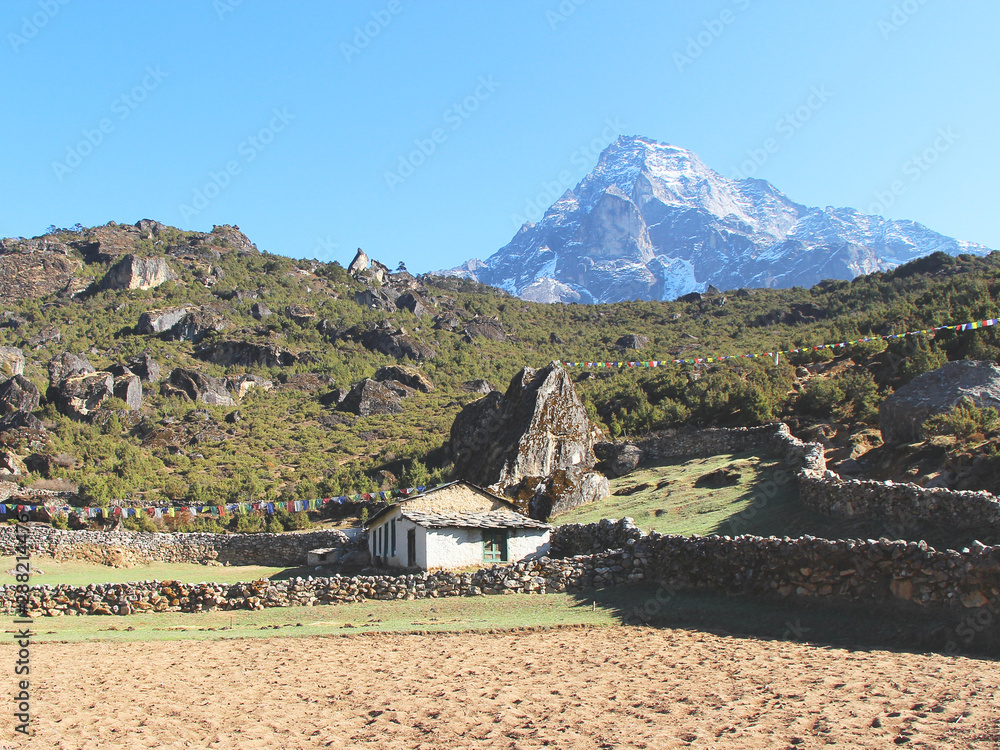 Khumbila mountain peak rises above one of residential sherpa stone