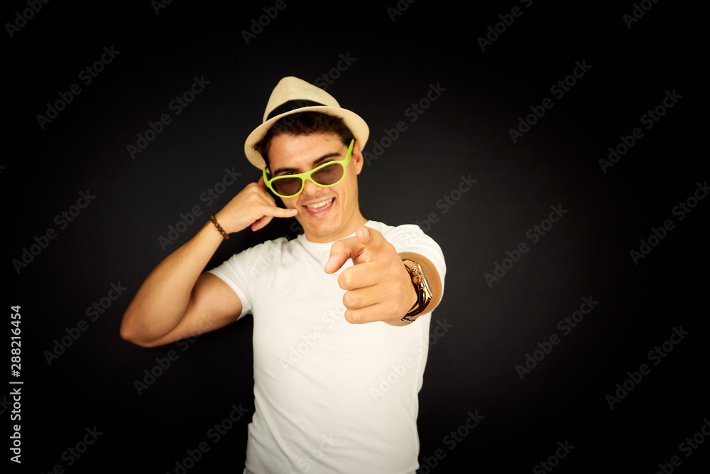 Young man making a call me sign and smiling Young man making a call me sign and smiling