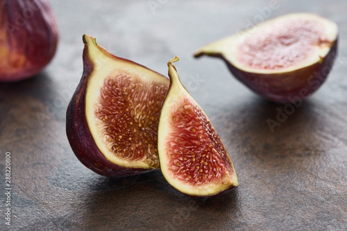 close up view of ripe cut delicious figs on stone background