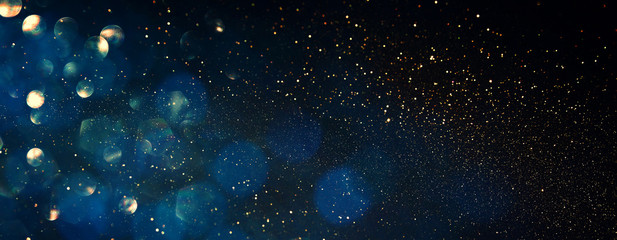 background of abstract glitter lights. blue, gold and black. de focused. banner