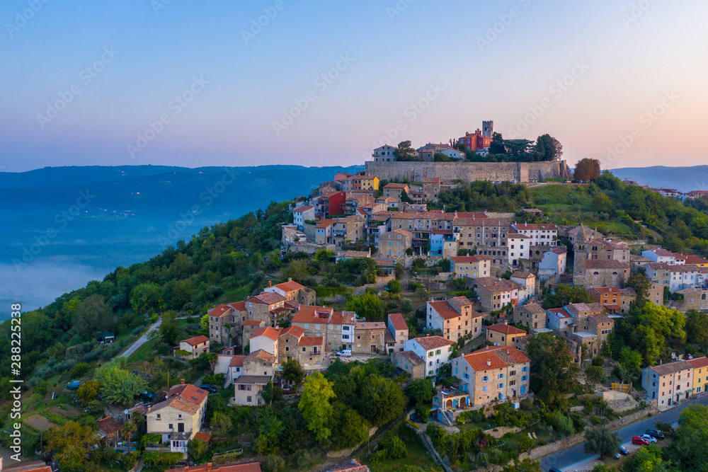 The ancient city of Motovun is located on the top of the mountain. The city is surrounded by a fortress wall. The background image are mountains and fog at the foot of the mountains. Istria, Croatia.