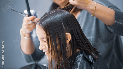 Madre cortando el cabello a su hija en casa